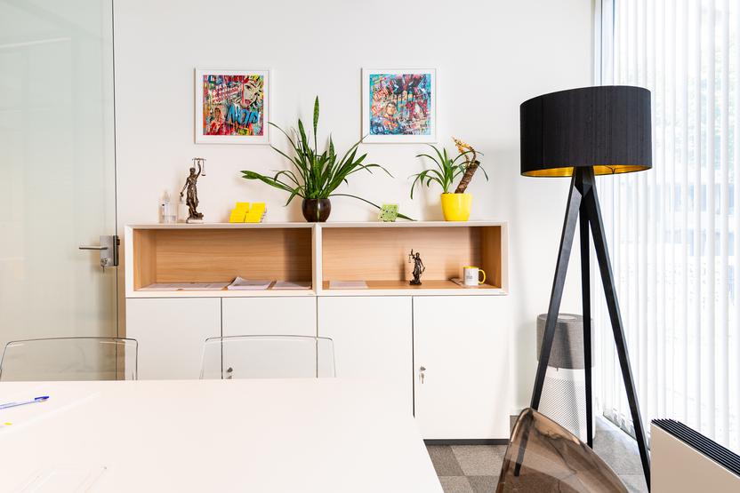 Am&eacute;nagement de bureau moderne avec &eacute;tag&egrave;re fabriqu&eacute;e sur mesure, plantes d&eacute;coratives, tableaux muraux et lampe sur pied noire &ndash; mobilier de qualit&eacute; pour espaces de travail