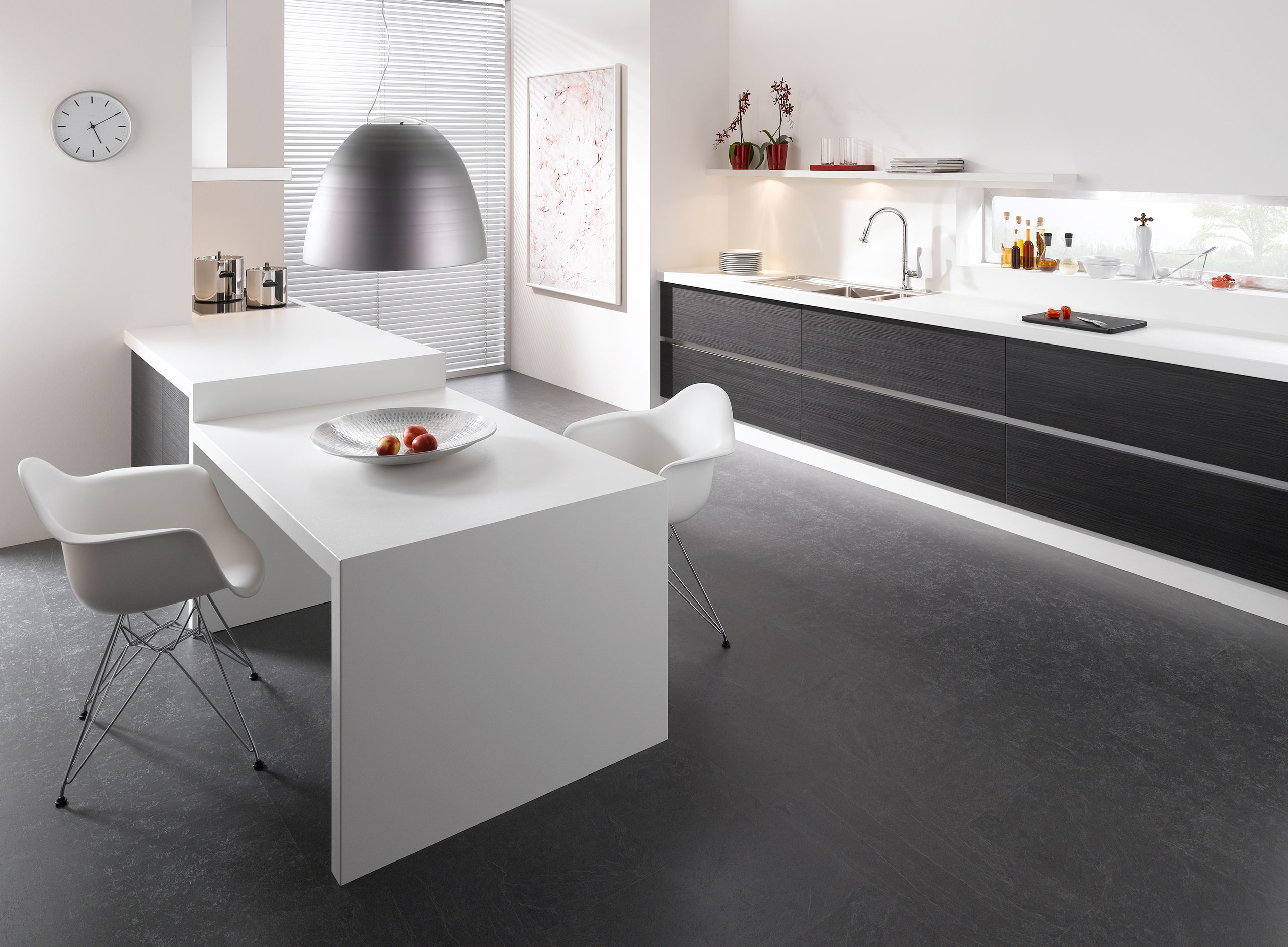 Impression einer einzeiligen Küchengestaltung in schwarz-weiß mit Esstisch für Zwei