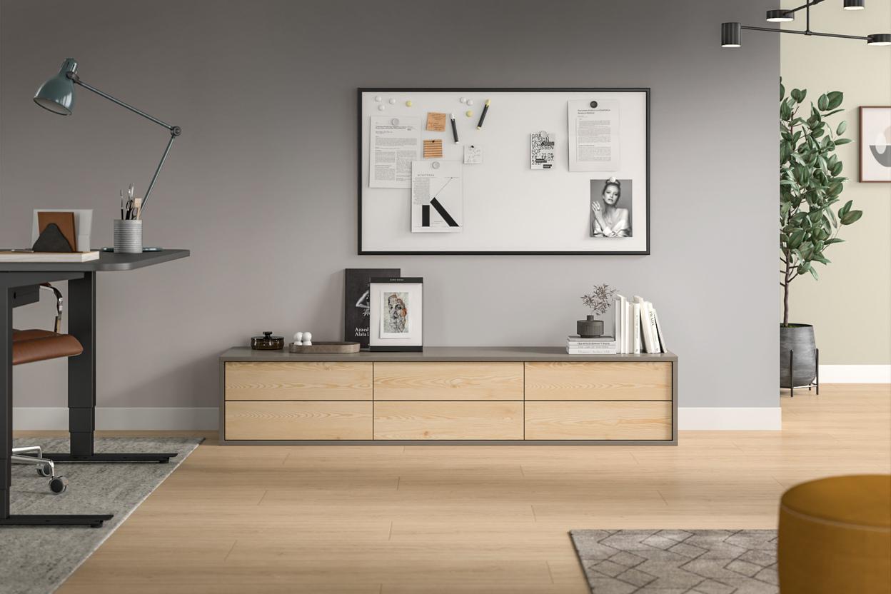 Elegantes Zimmer mit maßgefertigtem Sideboard Wohnraum mit hellem, maßgeschneidertem Sideboard aus Holz, darüber eine Pinnwand und Dekorationen.