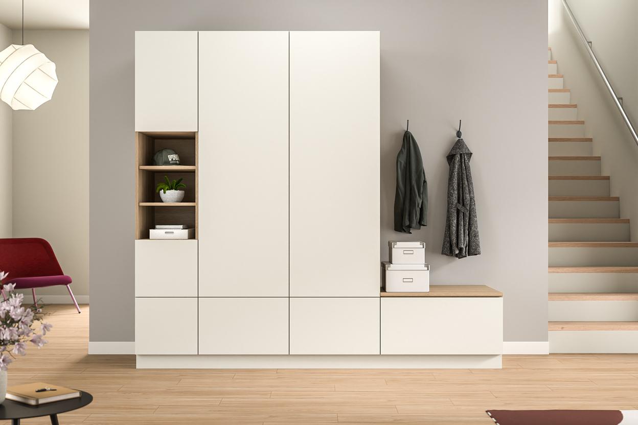 Maßgefertigter, multifunktionaler Schrank im hellen Eingangsbereich. Helle, maßgeschneiderte Schrankeinheit im Flur mit offenem Fach, Schubladen und integrierter Garderobe, harmonisch kombiniert mit warmen Holztönen.