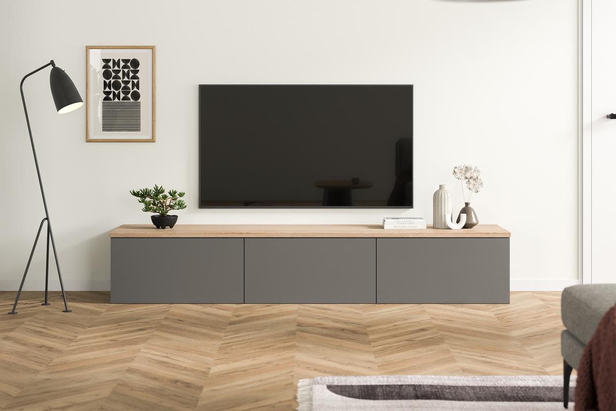 Elegante Kommode nach Maß im modernen Wohnzimmer Maßgefertigte, dunkelgraue Kommode unter einem Flachbildfernseher, kombiniert mit einer warmen Holzplatte, minimalistischer Dekoration und einem schwarzen Stehlampe daneben.